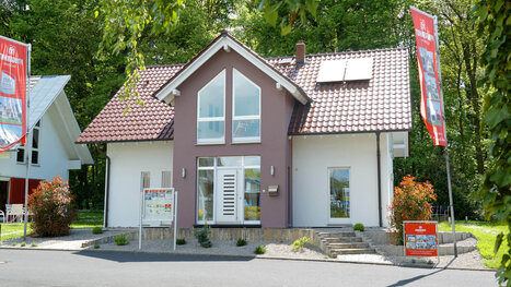 Fingerhut Einfamilienhaus braunes Satteldach weiß verputzt teilweise farblich braun abgesetzt weiße Haustüre weiße Fenster 