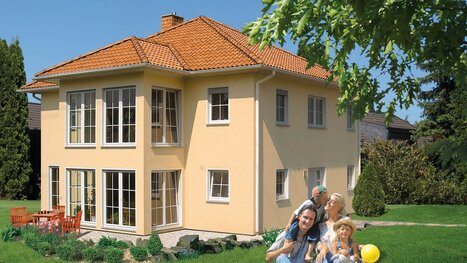 Fingerhut Mehrfamilienhaus Stadtvilla lachsfarben verputzt mit rot/orangen Dachziegel bodentiefe Terrassenfenster 