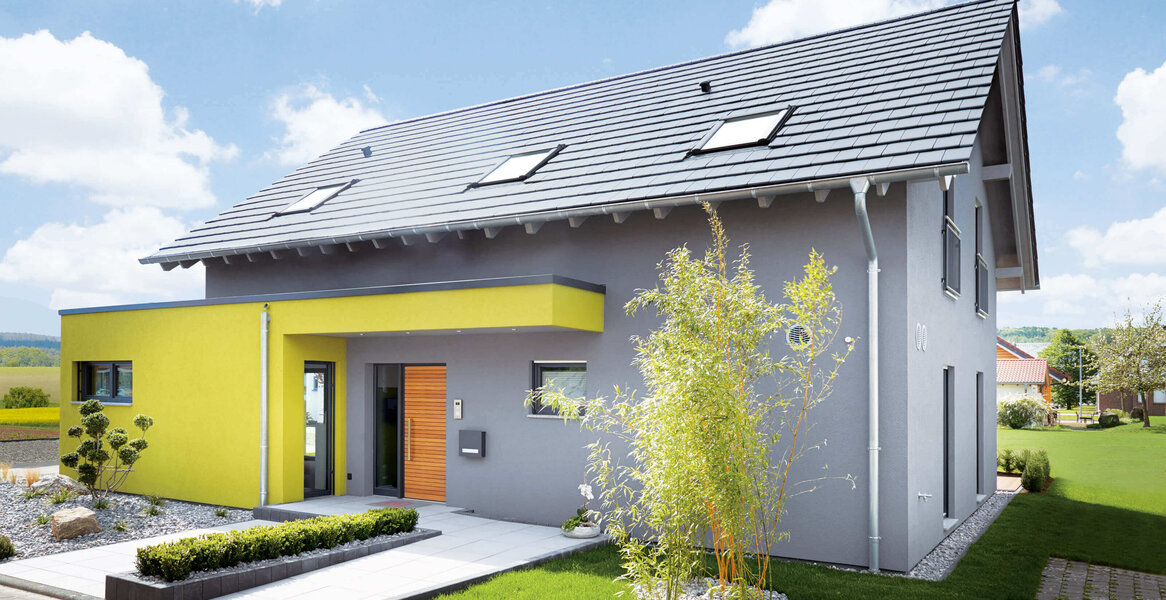 Fingerhut Einfamilienhaus schwarzes Satteldach grau verputzt teilweise farblich abgesetzt Holzhaustüre 
