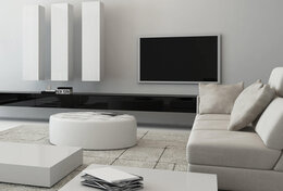Wohnzimmer weiße Wände helle Couch weißer runder Tisch Fernseher 