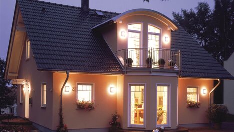Fingerhut Einfamilienhaus dunkles Satteldach mit Gaube beleuchtet 