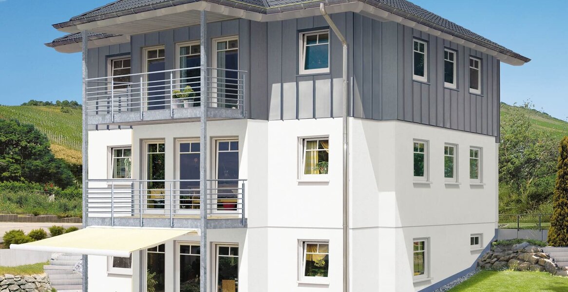 Fingerhut Mehrfamilienhaus hell verputz mit Blechverkleidung dunkles Dach Balkone 